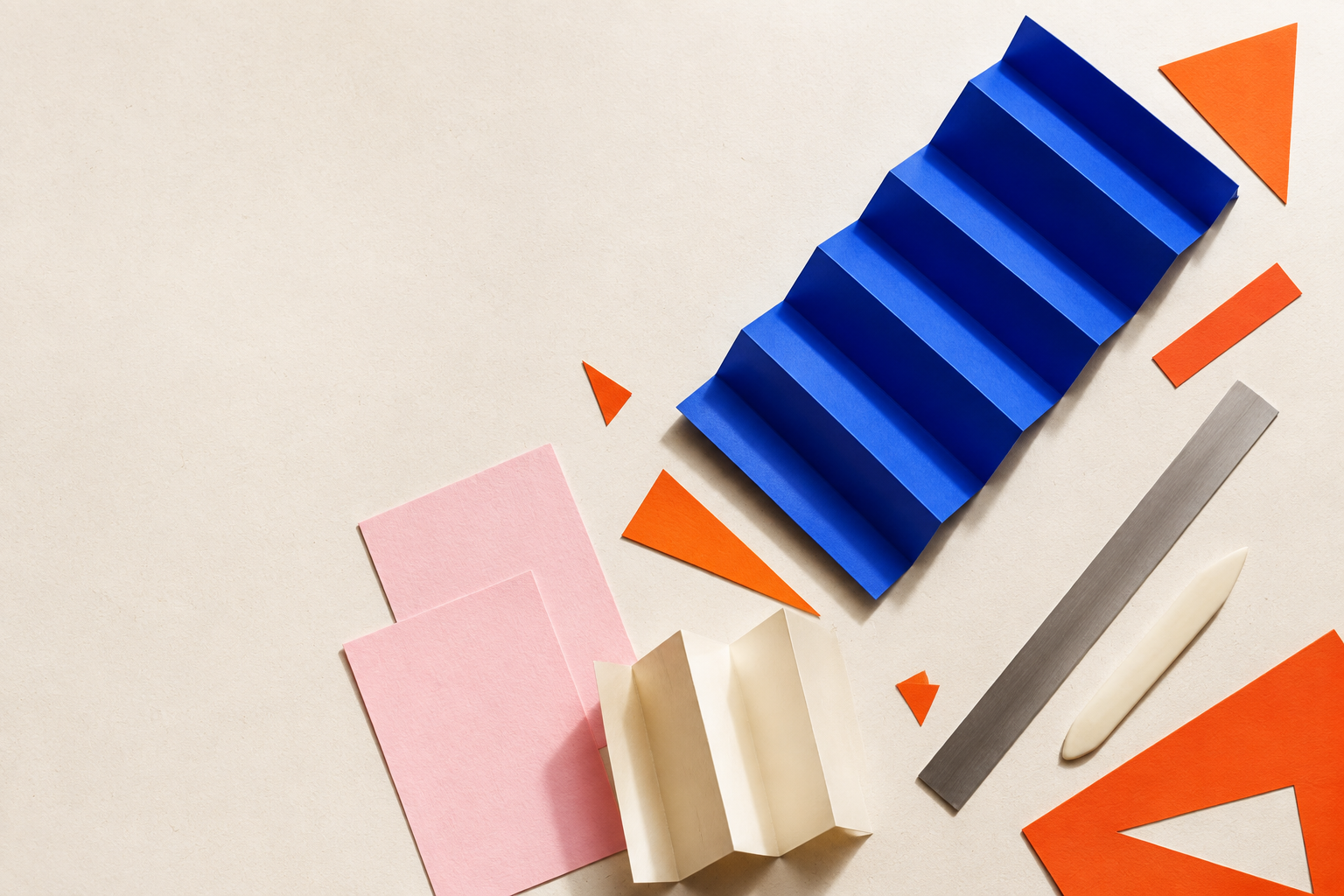 Original overhead arrangement of paper-making tools and folded coloured paper